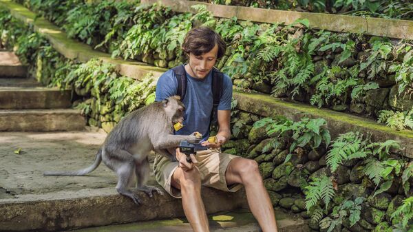 Мужчина делает селфи с обезьяной