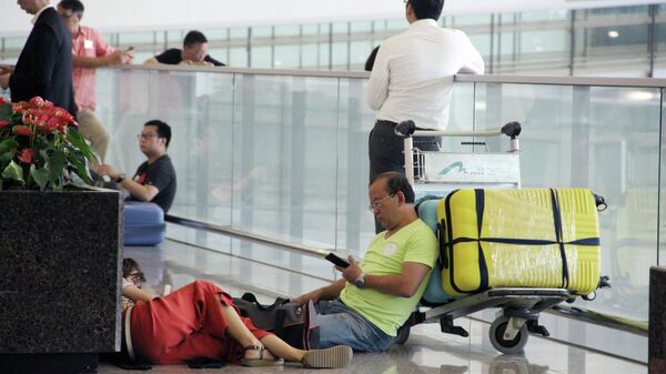 Пассажиры в международном аэропорту Гонконга во время акции протеста