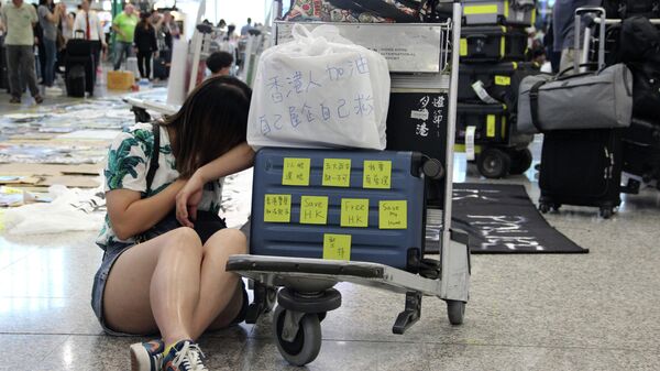 Пассажиры в международном аэропорту Гонконга во время акции протеста