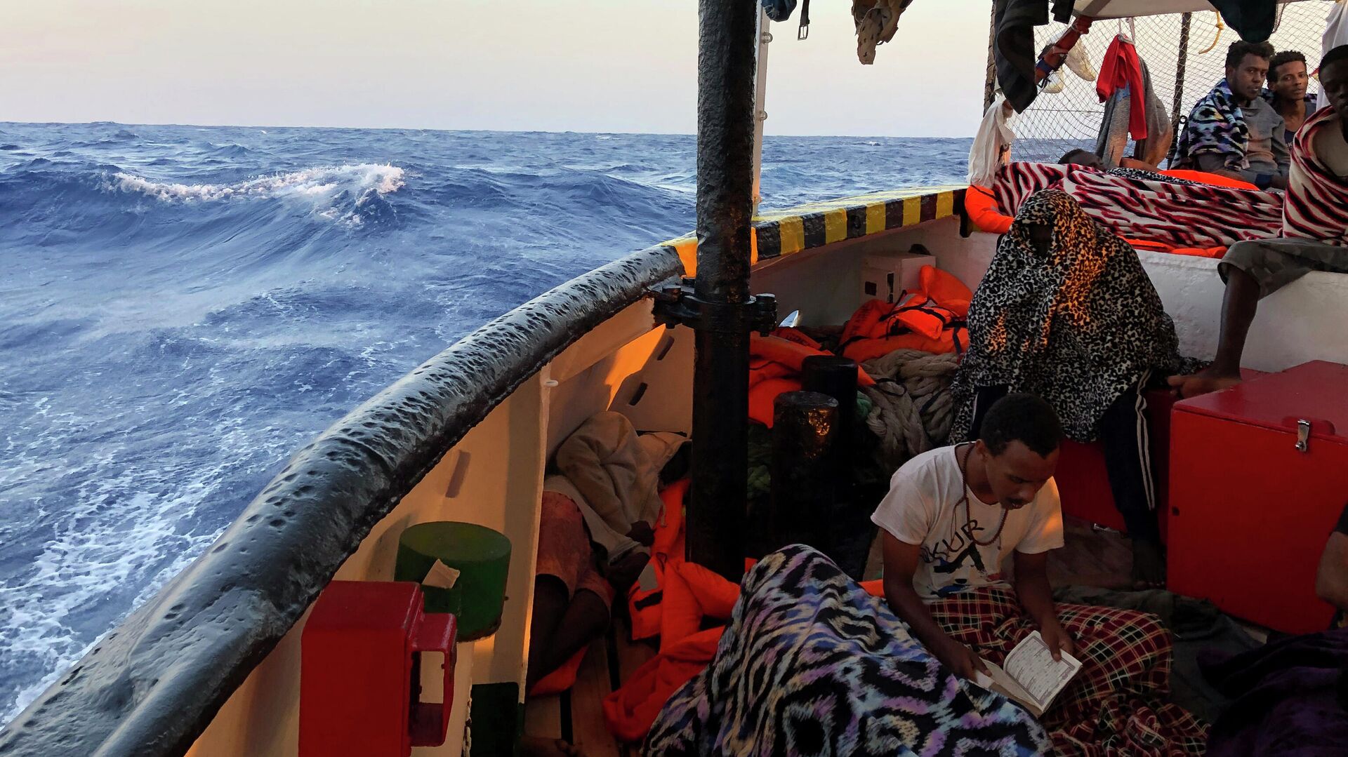 Мигрант читает Коран на борту судна испанских спасателей - РИА Новости, 1920, 01.01.2022