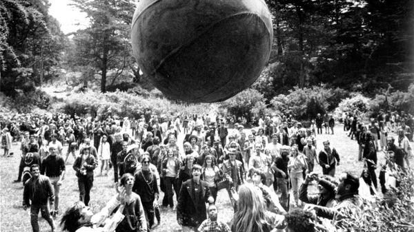 Хиппи запускают воздушный шар с изображением глобуса во время Лета любви в Сан-Франциско. Июнь 1967 года