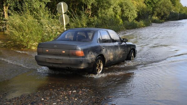 Автомобиль на подтопленной паводком дороге в районе Уссурийска