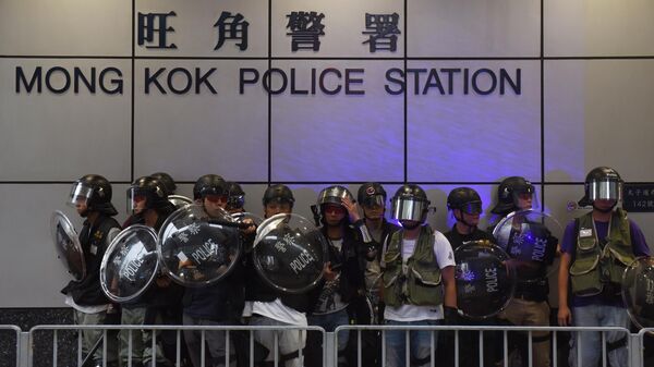 Полицейские у полицейского участка во время акции протеста оппозиционеров в Гонконге