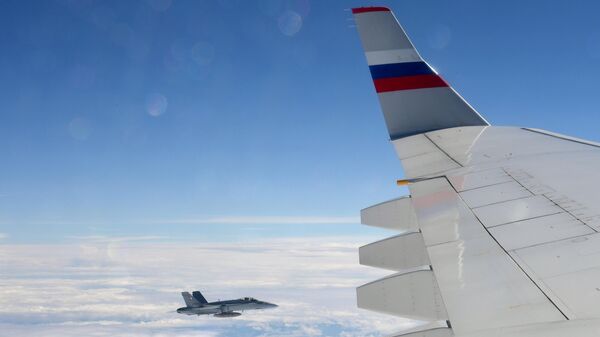 Истребитель Ф/A-18 Хорнет ВВС Швейцарии сопровождает российский пассажирский самолет