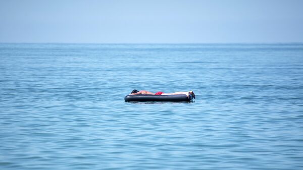 Мужчина на надувном матрасе в море