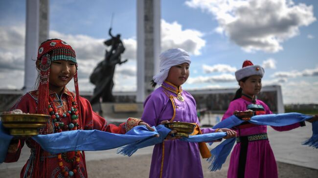 Девочки в национальных костюмах возле Мемориала, посвященного монгольским революционерам и героям войны, в городе Чойбалсан