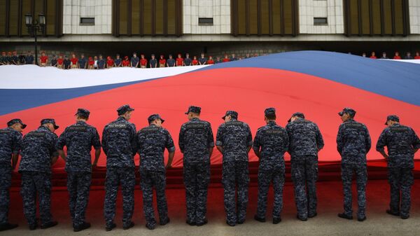 Участники флешмоба развернули государственный флаг Российской Федерации на площади Парка Победы на Поклонной горе в рамках празднования Дня государственного флага России