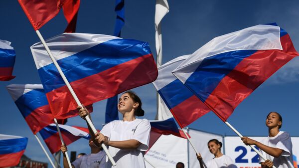 Участницы торжественного мероприятия, посвященного празднованию Дня государственного флага Российской Федерации, на площади Маркса в Новосибирске