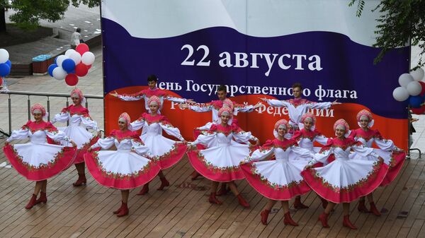 Выступление артистов на праздничном концерте, посвященном Дню государственного флага Российской Федерации, на набережной Спортивной гавани во Владивостоке