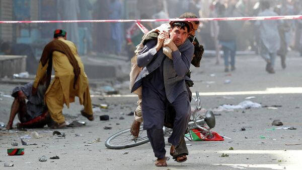 Мужчина несет раненого в госпиталь в Джелалабаде, Афганистан 