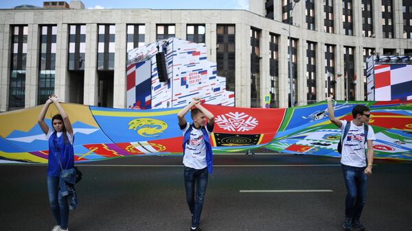 Участники флешмоба в честь Дня государственного флага России развернули на проспекте Сахарова в Москве полотно, состоящее из 2 тысяч флагов российских городов и общественных организаций