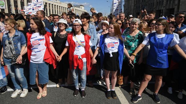 Участники флешмоба в честь Дня государственного флага России на проспекте Сахарова в Москве