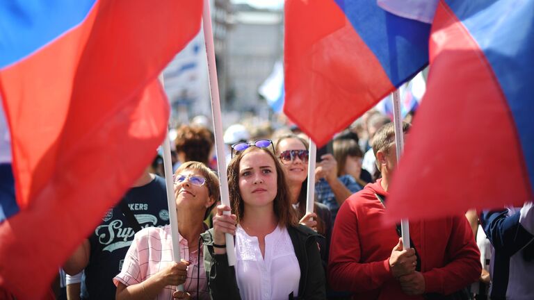 Участники флешмоба в честь Дня государственного флага России на проспекте Сахарова в Москве