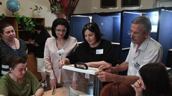 Сотрудники избирательной комиссии вскрывают урну для выездного голосования, чтобы подсчитать голоса на выборах президента Абхазии