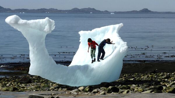 Дети играют на айсберге на пляже в Нууке, Гренландия
