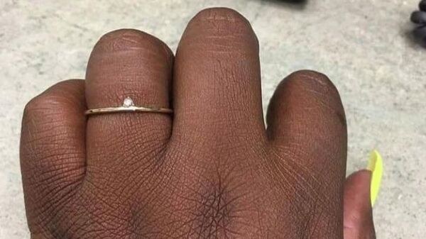 Фотография помолвочного кольца, к которому прикреплен маленький бриллиант