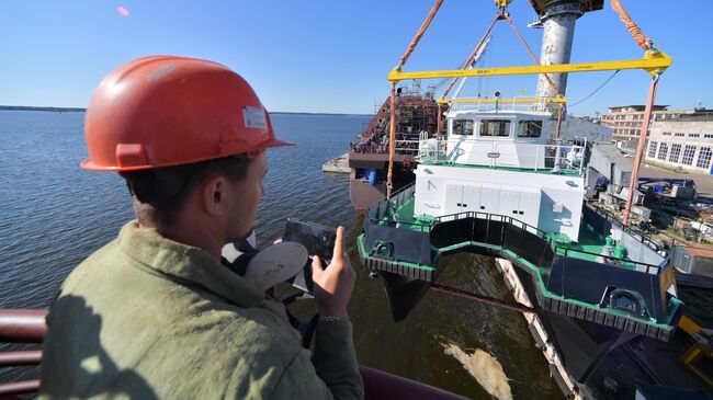 Рабочий Выборгского судостроительного завода снимает спуск на воду гидрографического катера-катамарана Михаил Казанский в Ленинградской области. 29 августа 2019 