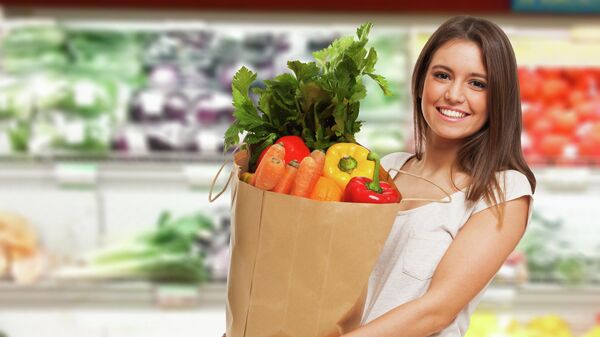Девушка покупает овощи в магазине 