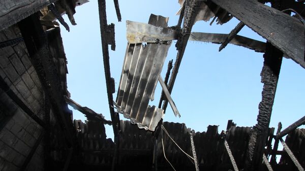 Сгоревший дом в результате обстрела украинскими силовиками в поселке Гольмовский