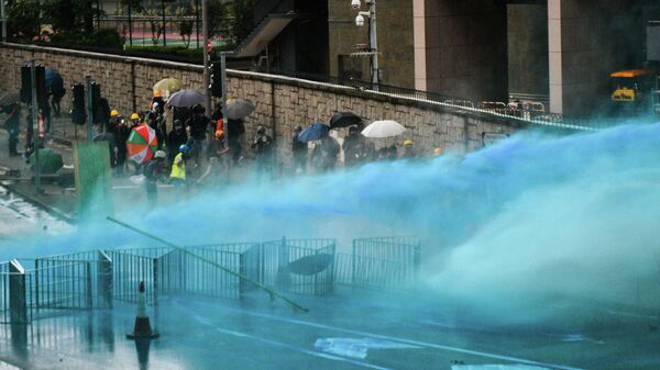 Гонконгская полиция разгоняет протестующих цветной водой. 31 августа 2019