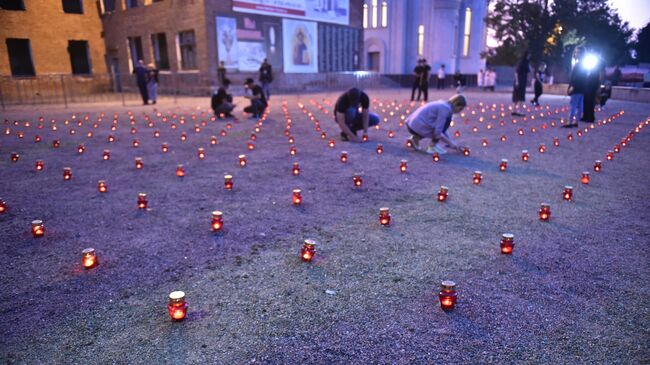 Жители зажигают свечи во дворе бывшей 1-й Бесланской школы в память погибших в теракте 1-3 сентября 2004 года