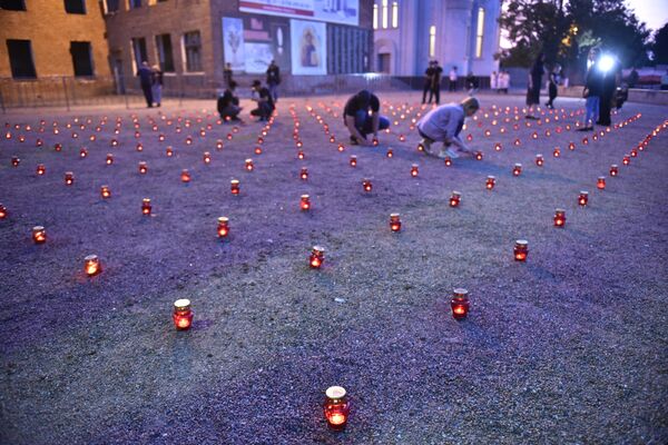 Жители зажигают свечи во дворе бывшей 1-й Бесланской школы в память погибших в теракте 1-3 сентября 2004 года