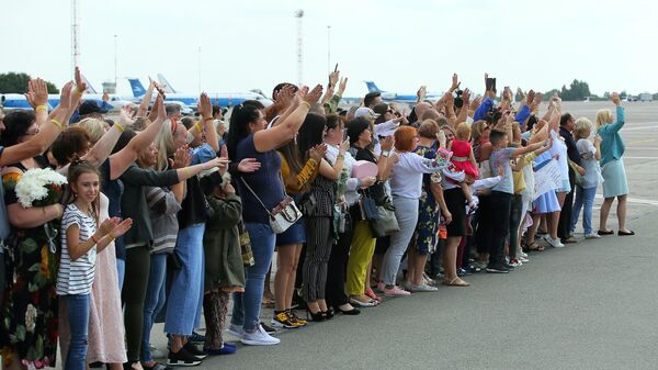 Родственники встречают самолет c участниками договоренности об освобождении между Россией и Украиной в аэропорту Борисполь