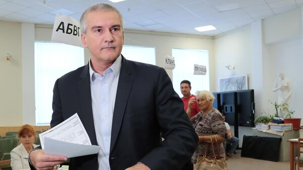 Глава Республики Крым Сергей Аксёнов голосует на выборах в единый день голосования на избирательном участке в Симферополе