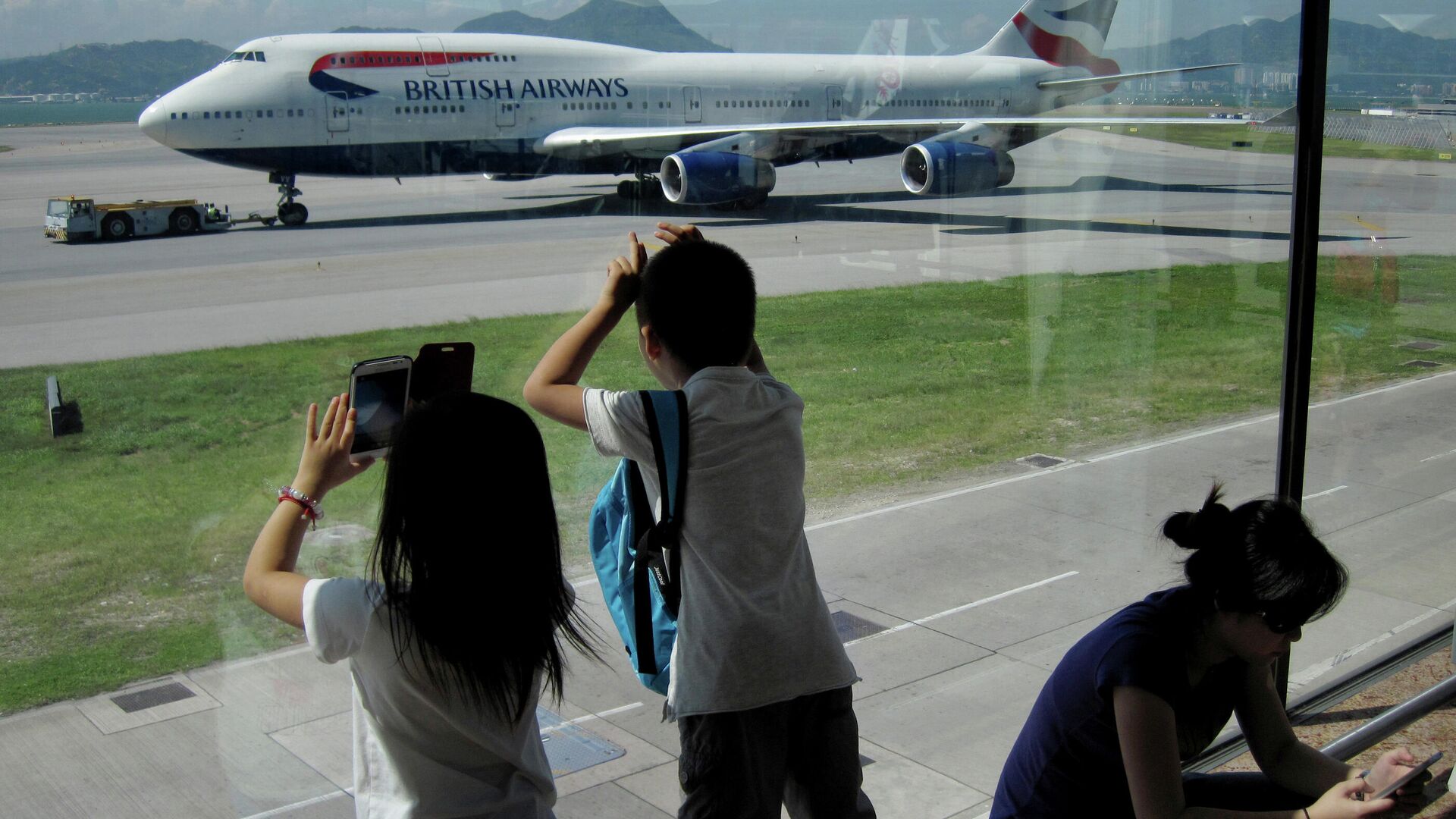 Пассажиры фотографируют Боинг 747 авиакомпании British Airways в международном аэропорту Гонконга - РИА Новости, 1920, 24.06.2021