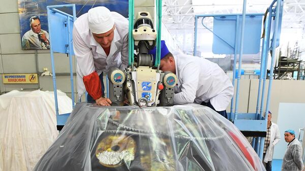 Сотрудники ракетно-космической корпорации Энергия извлекают робота Федора из спускаемого аппарата космического корабля Союз МС-14 после полета на МКС