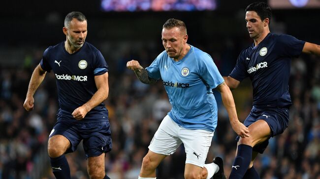 Premier League All-stars XI's Ryan Giggs (L) and Premier League All-stars XI's Spanish midfielder Mikel Arteta (R) vie with Manchester City Legend's Welsh forward Craig Bellamy during the Vincent Kompany testimonial football match between the Manchester City Legends and the Premier League All-stars XI at the Etihad Stadium in Manchester, northwest England, on September 11, 2019. (Photo by Paul ELLIS / AFP)