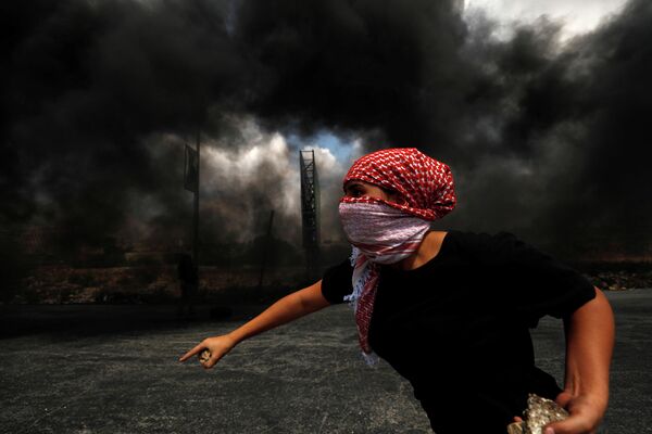 Палестинец во время протеста в израильском поселении Бейт-Эль на Западном берегу реки Иордан 