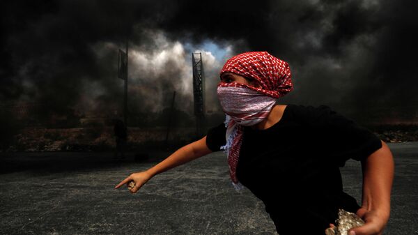 Палестинец во время протеста в израильском поселении Бейт-Эль на Западном берегу реки Иордан 