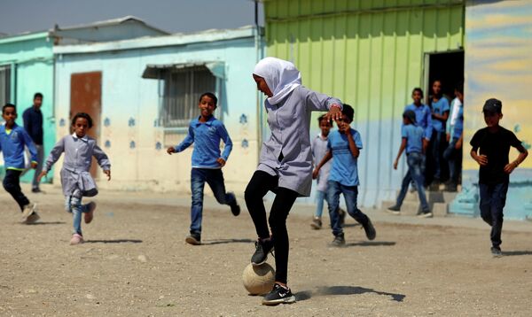 Палестинцы играют в футбол во дворе школы на Западном берегу реки Иордан