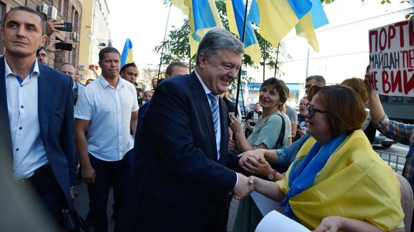 Бывший президент Украины Петр Порошенко пожимает руки своим сторонникам около здания Государственного бюро расследований Украины