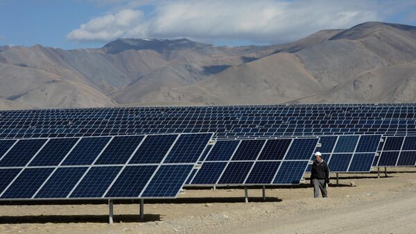 Мастер осматривает солнечные батареи на Кош-Агачской солнечной электростанции в Республике Алтай