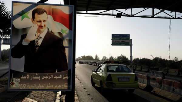 Плакат с портретом президента Сирии Башара Асада на дороге к аэропорту Дамаска