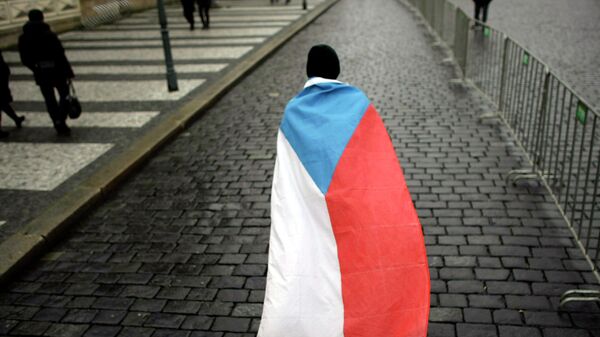 Мужчина с государственным флагом на улице Праги. Архивное фото