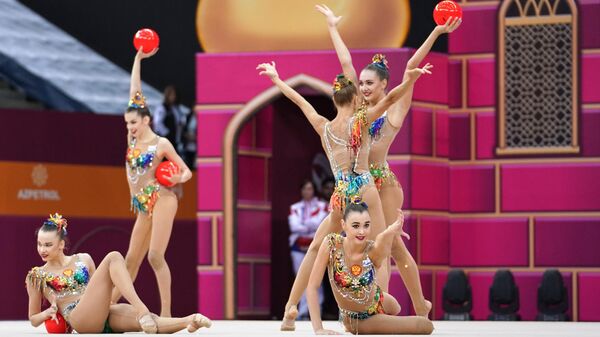 Гимнастки сборной России выполняют упражнения с пятью мячами в финале групповых соревнований в отдельных видах на чемпионате мира по художественной гимнастике 2019 в Баку. 