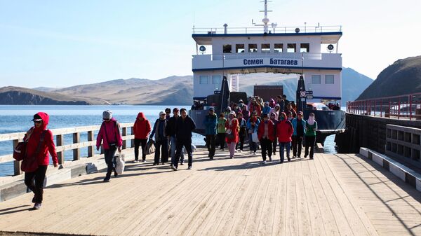 Иностранные туристы на паромной переправе острова Ольхон на озере Байкал в Иркутской области