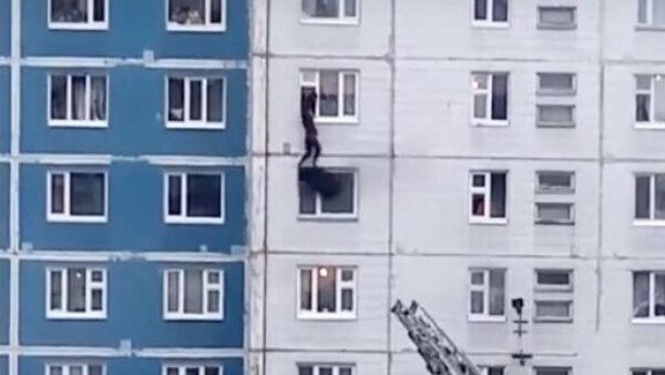 Стоп-кадр видео спасения девушки во время пожара в жилом доме в Нижневартовске