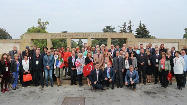 Участники международной конференции Память победителей фотографируются около Мемориала освободителям Белграда