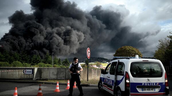 Полицейский на шоссе Ле-Пети-Кевилле, перекрытом в связи с задымлением из-за пожара на заводе  Lubrizol в Руане, Франция. 26 сентября 2019