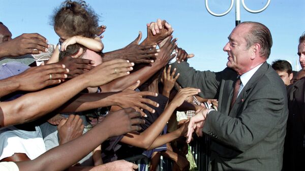 Президент Франции Жак Ширак обменивается рукопожатиями с местными жителями по прибытии в аэропорт им. Памандзи на Майотте. 19 мая 2001 года