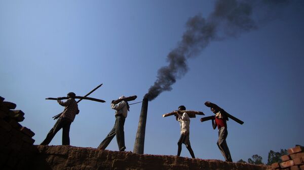 Рабочие на кирпичном заводе на окраине Джамму в Индии