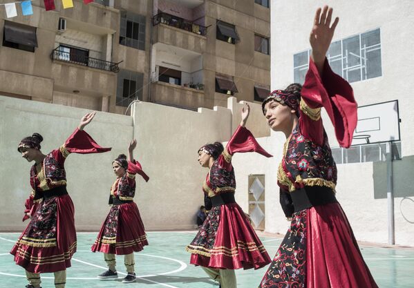 Выступление девушек в национальных костюмах на открытии школы в районе Барза в Дамаске, отремонтированной на собранные в России средства
