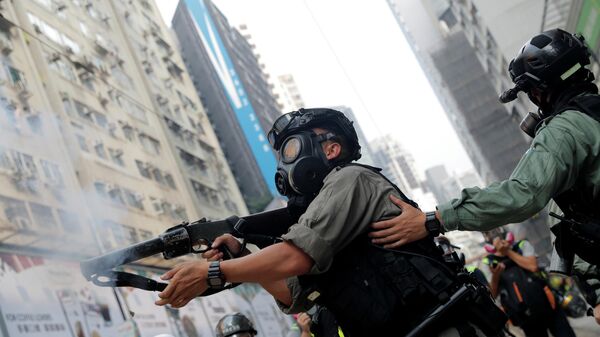 Сотрудник полиции применяет слезоточивый газ во время демонстрации в Гонконге, Китай. 29 сентября 2019 