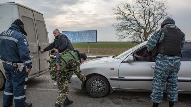 Сотрудники правоохранительных органов проверяют граждан на блокпосту на перешейке в районе Чонгара