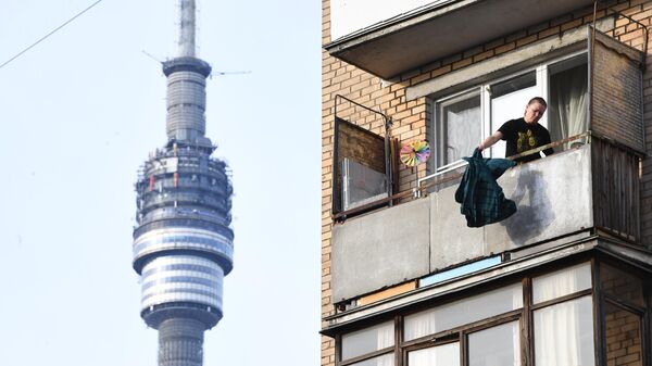 Женщина на балконе жилого дома в Москве.