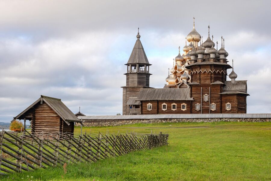 Преображенская церковь XVIII века после реставрации, церковь Покрова Пресвятой Богородицы и колокольня, входящие в состав архитектурного ансамбля Государственного историко-архитектурного музея-заповедника Кижи, на острове Кижи Онежского озера в Карелии